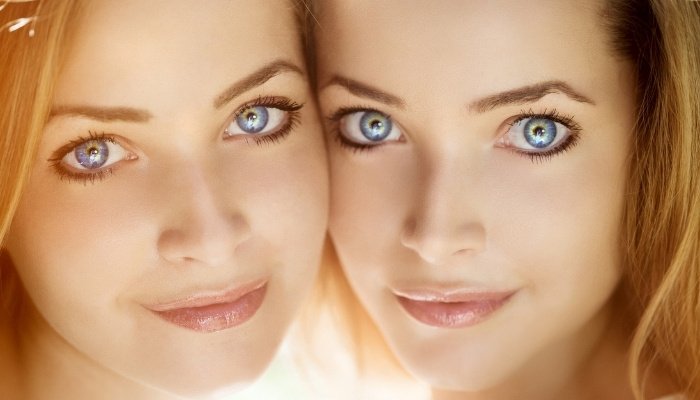 The faces of beautiful adult twin sisters.