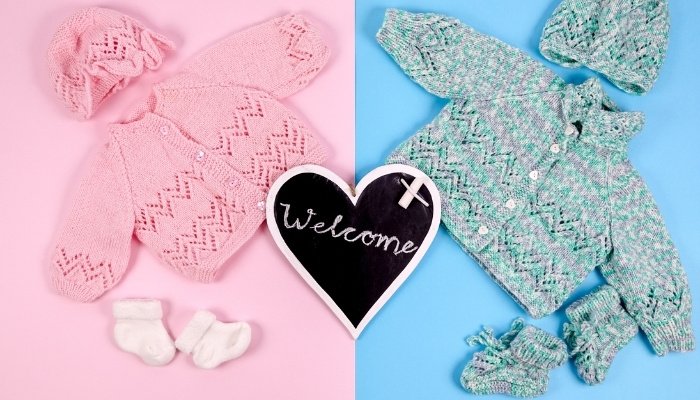 Twin sweater sets in pink and blue with a welcome sign.
