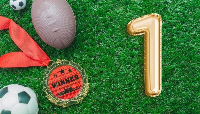 Sports props and #1 balloon on grass for a photoshoot.