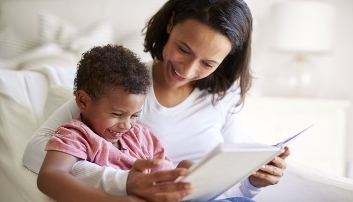 A mother reading a book with her toddler.