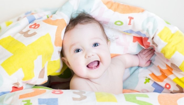 Cute baby playing under a blanket on his tummy.