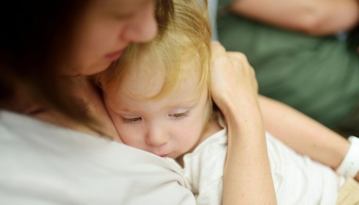 A mother holding her upset child close to offer comfort.