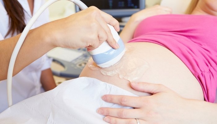 A woman is being given an ultrasound to check on her pregnancy.