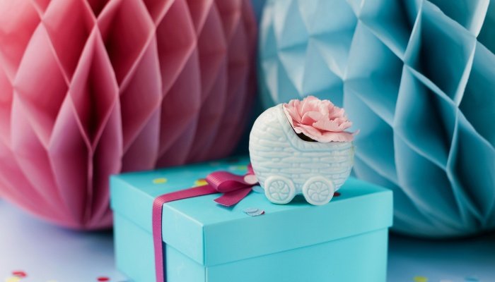Pink and blue decorations and a gift for a gender-reveal party.