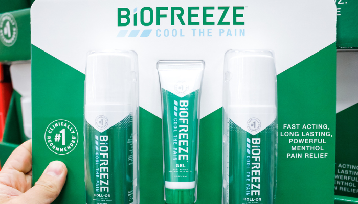 A hand holding a pack of Biofreeze containing three different application options.