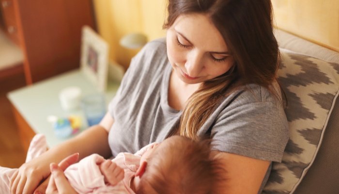 A young mother gazing lovingly at her nursing child.