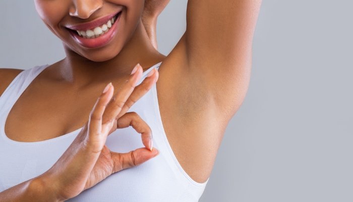 Woman exposing her armpit and giving the okay sign.