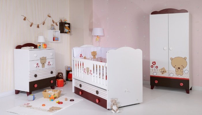 A baby nursery decorated in brown, pink, and white with bear accents.