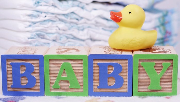 The word BABY spelled out with children's blocks. A rubber duck sits on top.
