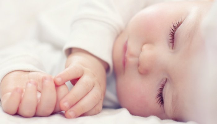A close-up look at a beautiful sleeping baby's face and hands.