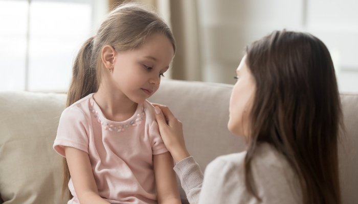 A mother having a serious talk with her young daughter.