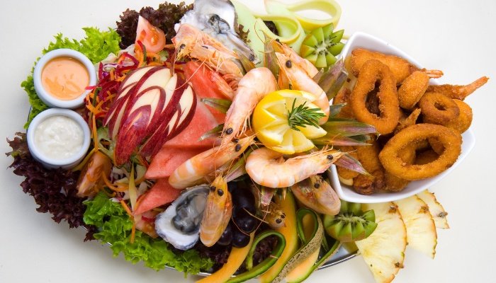 A platter of assorted types of seafood against a white background.