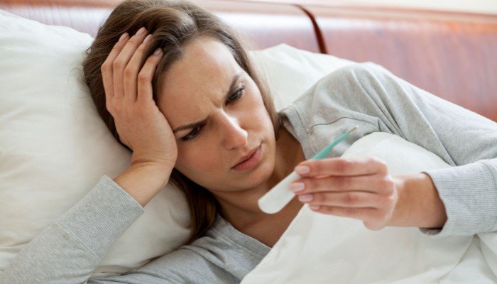 Woman Checking Her Temperature in Bed