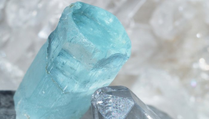 A rough aquamarine crystal on top of clear quartz.