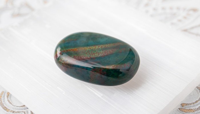 A bloodstone crystal on a white linen cloth.