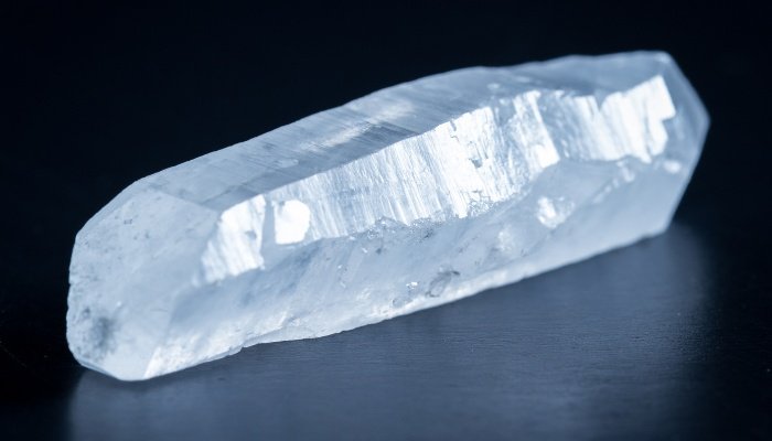 A clear quartz crystal on a black background.