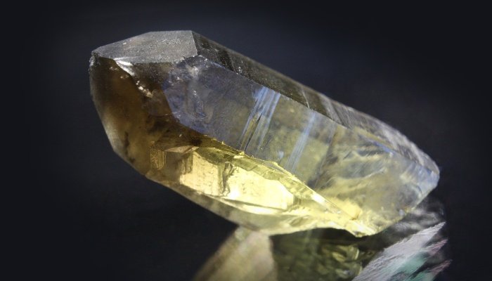 A smoky quartz crystal on a black background.
