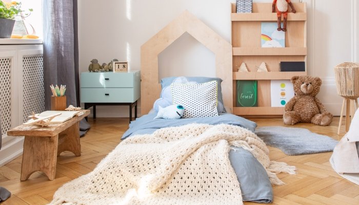 A child's cute bedroom with a floor bed positioned in the middle.