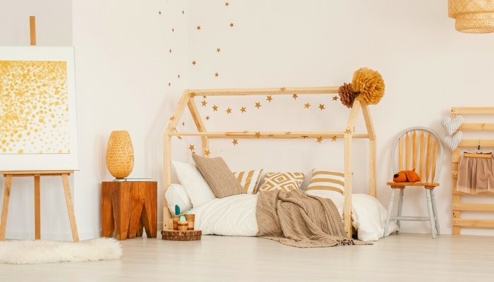 A child's room with an easel, small table, and floor bed.