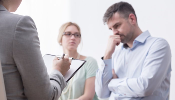 A man and woman sitting through a counseling session for parenting.