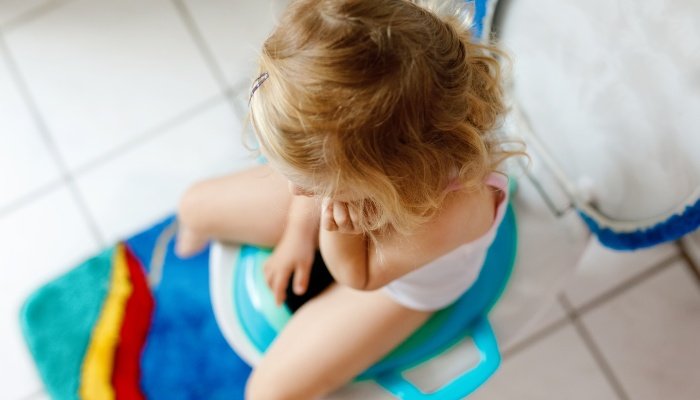A toddler sitting on the toilet as viewed from above.