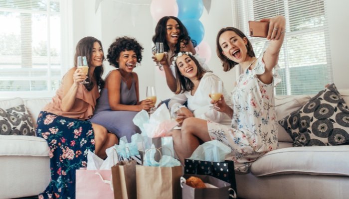 A group of women taking selfies at a baby shower.