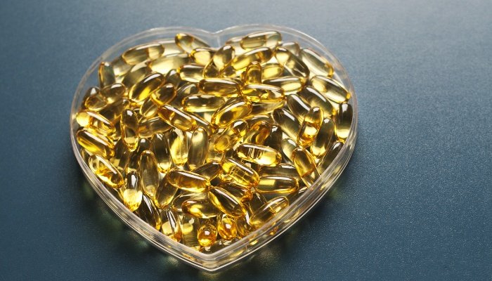 A heart-shaped bowl of evening primrose oil capsules.