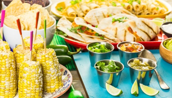 A buffet table loaded with Mexican dishes for a fiesta-themed party.
