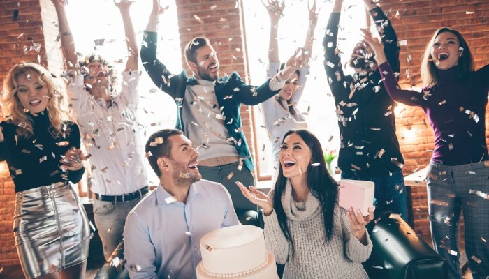 Men and women celebrating with confetti at a co-ed baby shower.