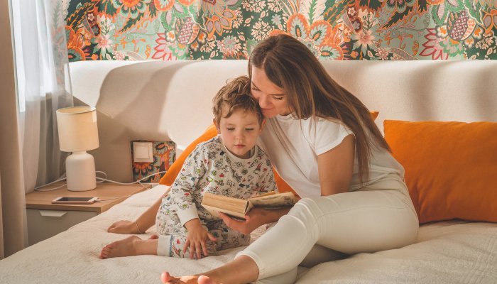 Mom Reading A Book To Son In Bed