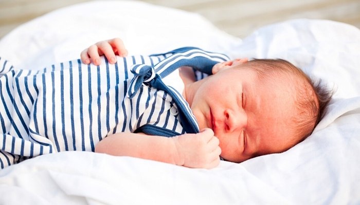 A newborn baby boy dressed in a sailor outfit.