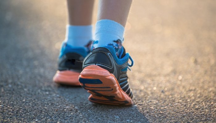 A close look at a boy's sneakers as he walks down the road.
